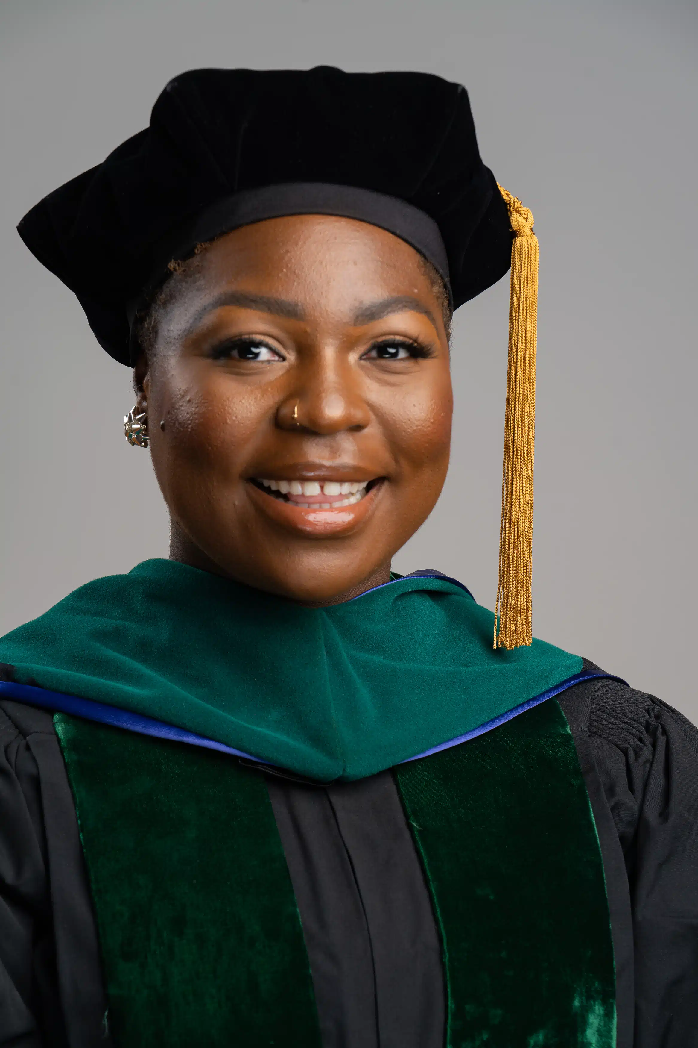 black woman ECU student graduating and taking pre graduation photos and headshot photos for medical school. While wearing cap and gown.