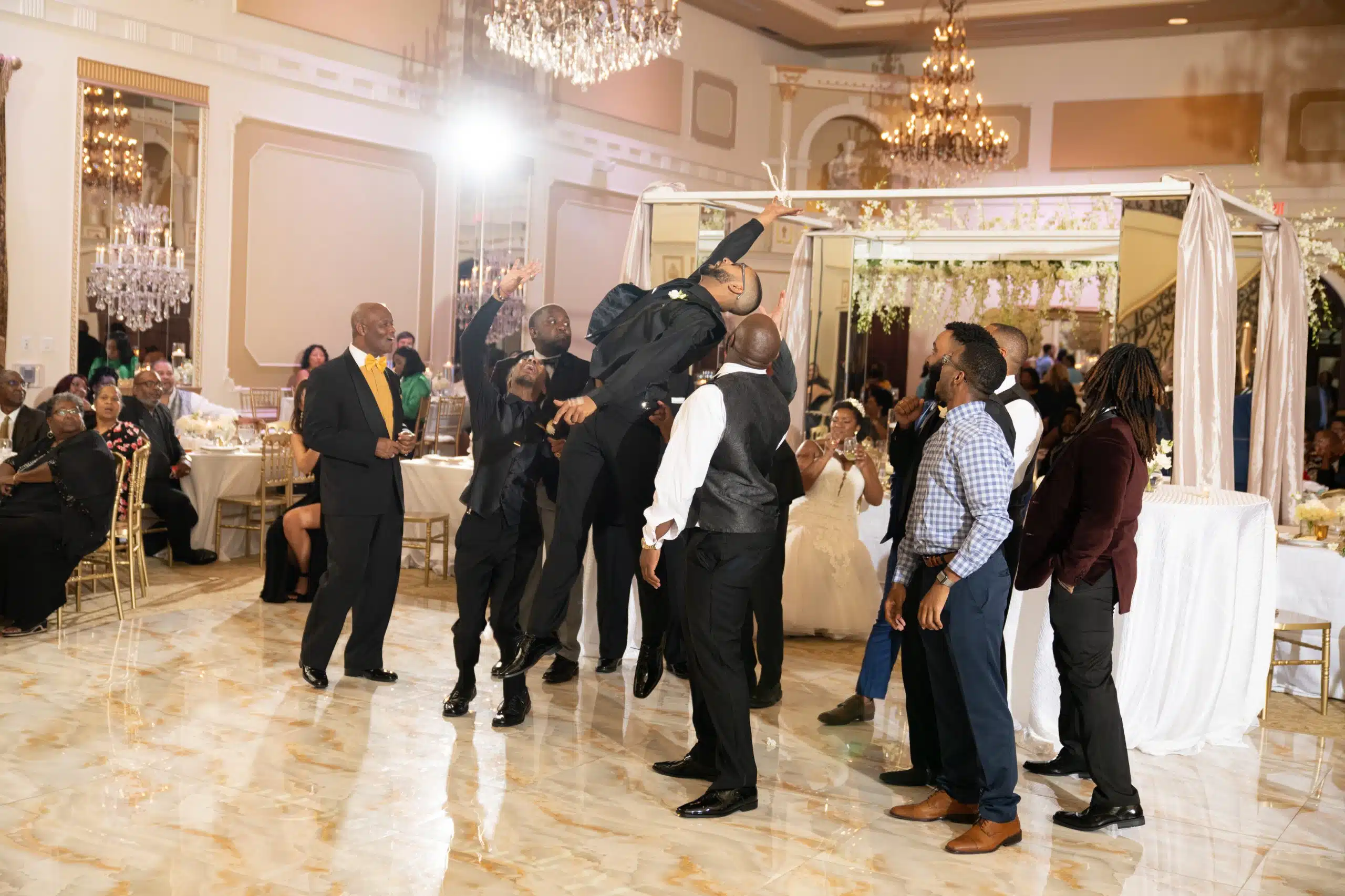 Man jump up high above everyone in a raleigh, nc wedding venue. This part of the wedding is a small detail of the wedding planning process.