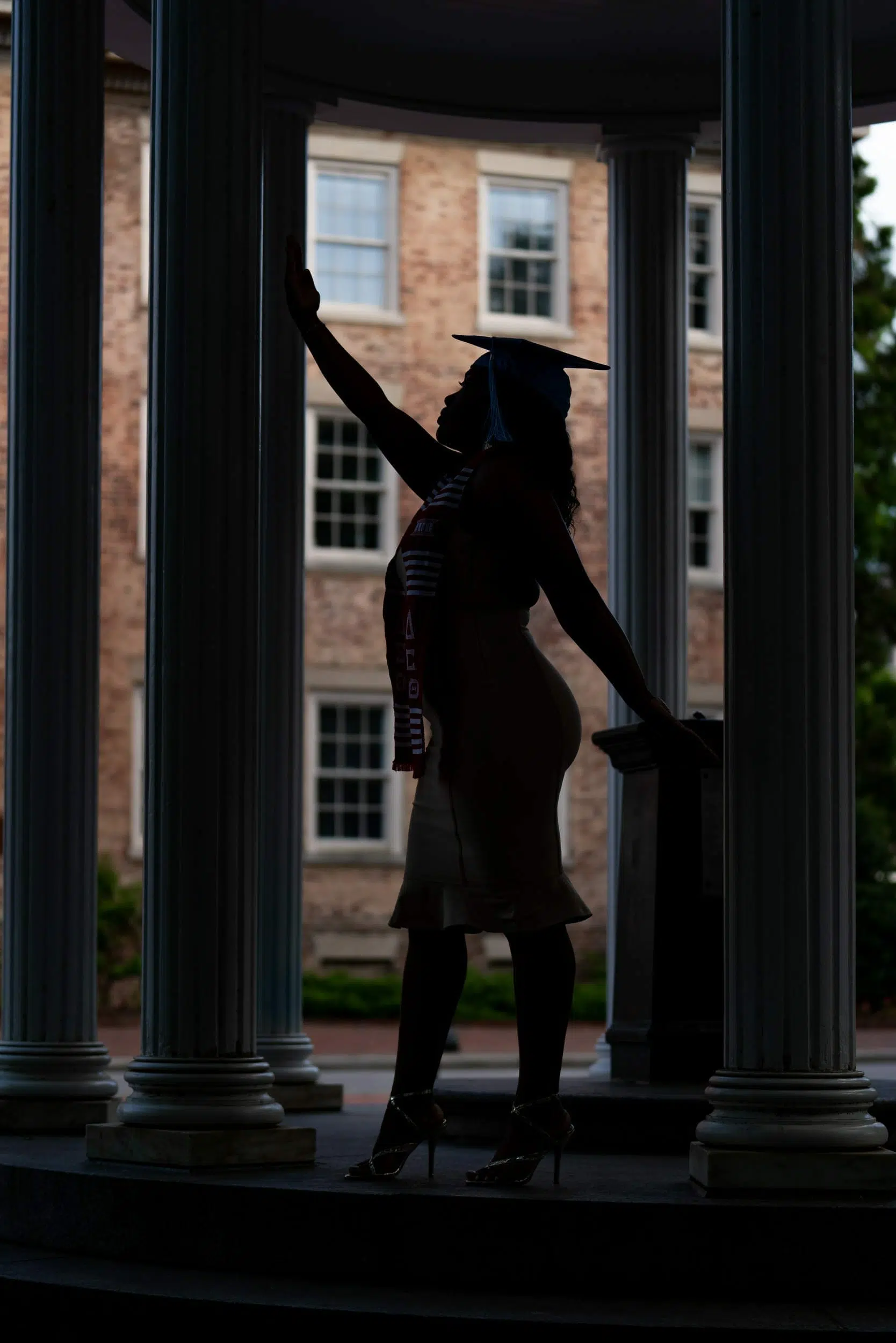Woman posing for her graduation photos at UNC school campus.